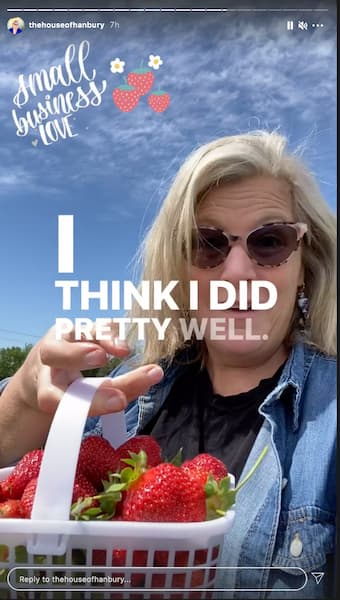 Laura smiles as she shares an Instagram™ Story video in a strawberry field.